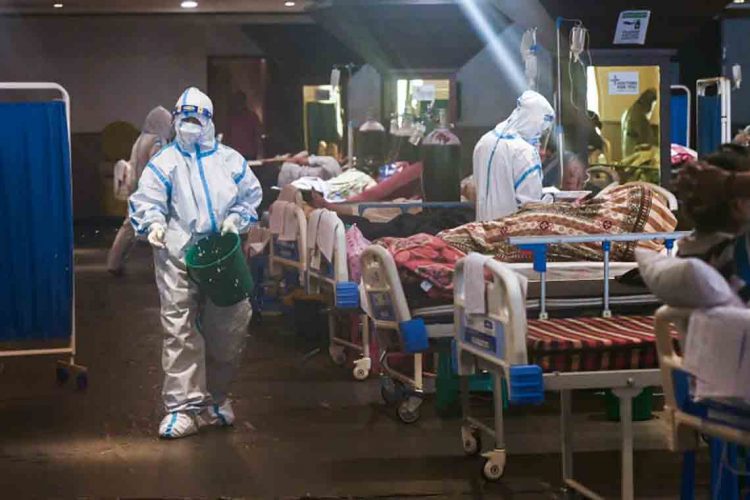 Health workers wearing a personal protective equipment (PPE) suits attend patients inside a banquet hall temporarily converted into a Covid-19 coronavirus ward in New Delhi on May 1, 2021. (Photo by Prakash SINGH / AFP)
