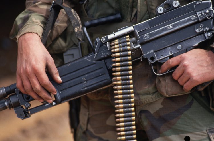 1993, Hohenfels, Germany --- A soldier holds a machine gun loaded with 5.56 caliber ammunition which it fires in short bursts. Hohenfels, Germany. --- Image by © Leif Skoogfors/CORBIS
