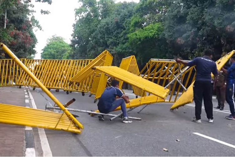 දැමූ මාර්ග බාධක ඉවත් කරන පොලිස් නිලධාරීයෙක්..