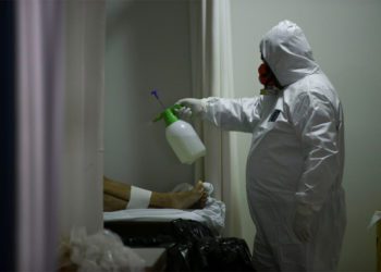 SENSITIVE MATERIAL. THIS IMAGE MAY OFFEND OR DISTURB    A worker of a funeral parlour, sanitises the dead body of an 83-years-old woman, who died of unknown reasons during the outbreak of the coronavirus disease (COVID-19), in Porto Alegre, Brazil, April 3, 2020. REUTERS/Diego Vara