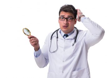 84496572 - young male doctor with a looking magnifying glass isolated on white background