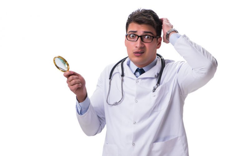 84496572 - young male doctor with a looking magnifying glass isolated on white background