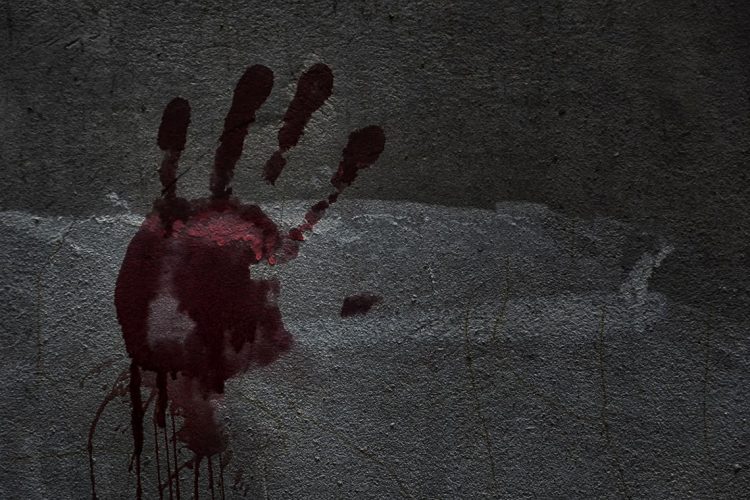 Blood of hand on a wall in an abandoned house them.The story about the murder.Background operators in Halloween festivities.