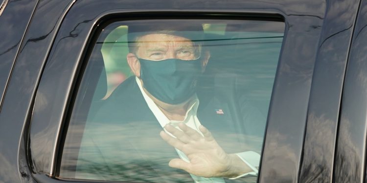 US President Trump waves from the back of a car in a motorcade outside of Walter Reed Medical Center in Bethesda, Maryland on Ocotber 4, 2020. (Photo by ALEX EDELMAN / AFP) (Photo by ALEX EDELMAN/AFP via Getty Images)