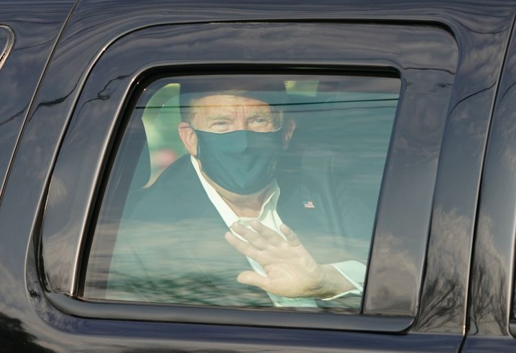 US President Trump waves from the back of a car in a motorcade outside of Walter Reed Medical Center in Bethesda, Maryland on Ocotber 4, 2020. (Photo by ALEX EDELMAN / AFP) (Photo by ALEX EDELMAN/AFP via Getty Images)