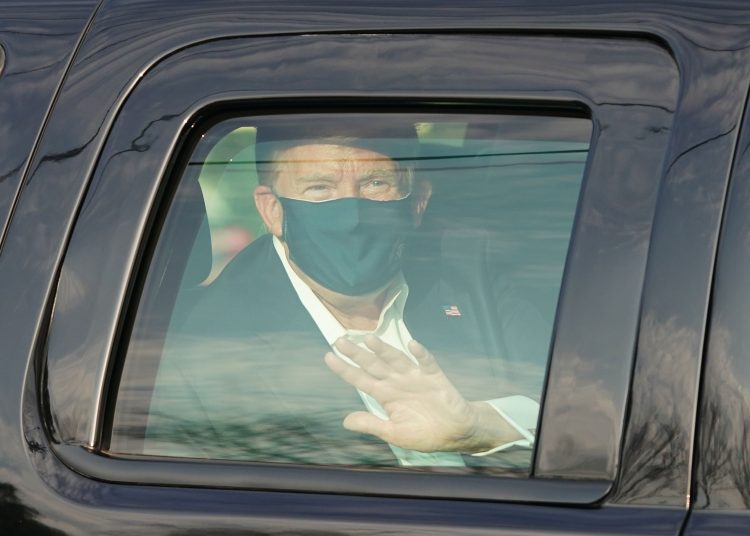 US President Trump waves from the back of a car in a motorcade outside of Walter Reed Medical Center in Bethesda, Maryland on Ocotber 4, 2020. (Photo by ALEX EDELMAN / AFP) (Photo by ALEX EDELMAN/AFP via Getty Images)