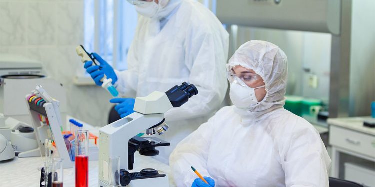 Scientists in protective suits in a science laboratory study a dangerous virus to eliminate the epidemic