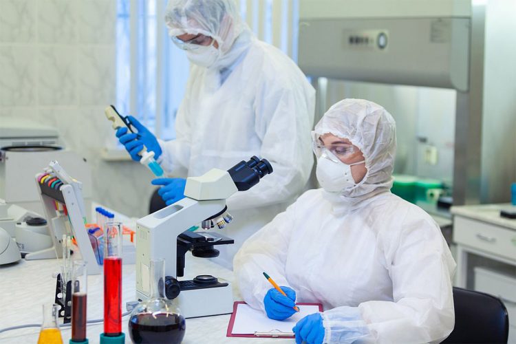 Scientists in protective suits in a science laboratory study a dangerous virus to eliminate the epidemic