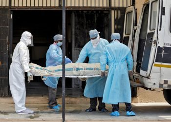 Municipal workers in protective gear carry the body a woman who died due to coronavirus disease (COVID-19), for her cremation at a crematorium in Ahmedabad, India, April 17, 2020. REUTERS/Amit Dave