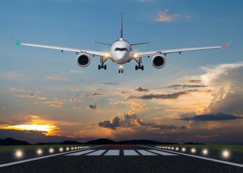 Airplane landing in the evening with beautiful sunset background