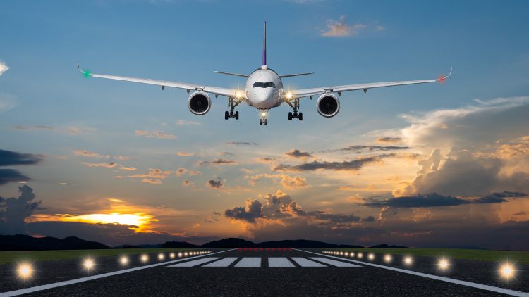 Airplane landing in the evening with beautiful sunset background