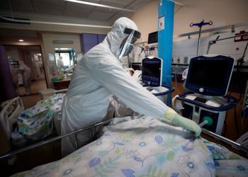 epa08712654 A family member wearing a full protective suit, mourn the death of their relative at the coronavirus COVID-19 department at the Galilee Hospital, in the northern city of Nahariya, Israel, 01 October 2020. According to media reports, hospitals in Israel are under a lot of pressure as the number of people infected with the virus continues to increase, and most of the recently diagnosed coronavirus patients are from the ultra-Orthodox sector. Israel is on a full three-week lockdown aimed to stem a new spike of COVID-19 coronavirus cases.  EPA/ATEF SAFADI