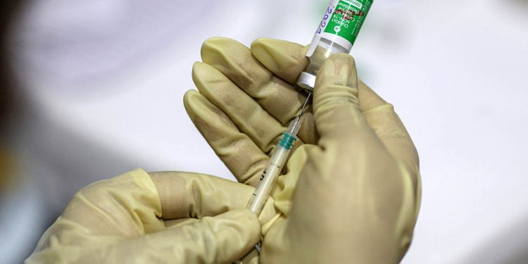 A nurse uses a syringe to draw from a vial of the Covishield vaccine, developed by Oxford-Astrazeneca Plc. and manufactured by Serum Institute of India Ltd., at a vaccine center in the Bandra Kurla Complex hospital in Mumbai, India, on Saturday, Jan. 16, 2021. India launched one of the worlds largest coronavirus vaccination drives on Saturday, setting in motion a complex deployment plan aimed at stemming the wide spread of infections across a nation of more than 1.3 billion people. Photographer: Dhiraj Singh/Bloomberg via Getty Images