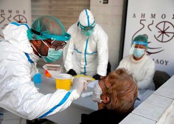 Medical staff conducts a rapid COVID test on an elderly woman in Athens, Monday, Nov. 23, 2020. Greece has seen a major resurgence of the virus after the summer, leading to dozens of deaths each day and thousands of new infections. (AP Photo/Thanassis Stavrakis)