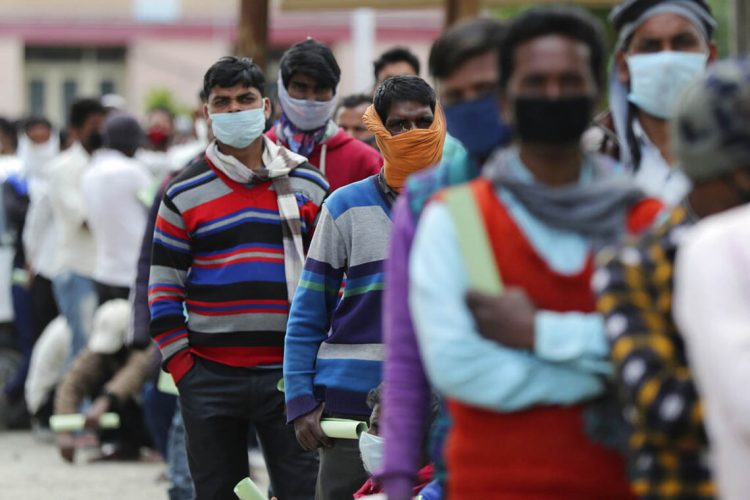 Indian migrant workers wait in a queue for medical examination outside a hospital in Srinagar, Indian controlled Kashmir, Monday, May 4, 2020. India's six-week coronavirus lockdown, which was supposed to end on Monday, has been extended for another two weeks, with a few relaxations. Locking down the country's 1.3 billion people has slowed down the spread of the virus, but has come at the enormous cost of upending lives and millions of lost jobs. (AP Photo/Mukhtar Khan)