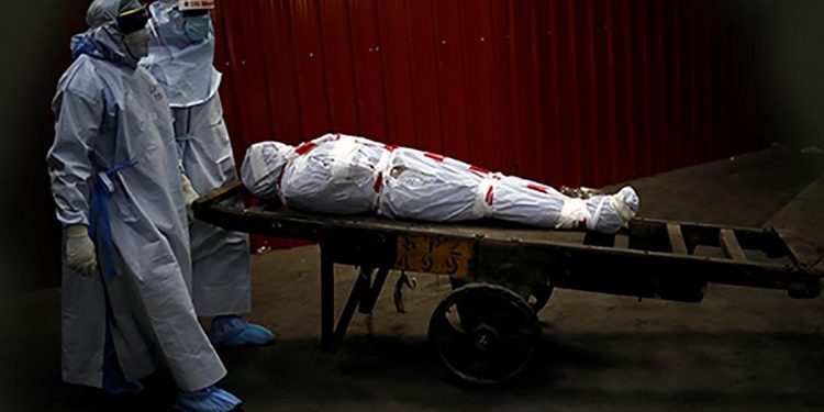 Health workers carry the body of a man who died due to the coronavirus disease (COVID-19) for his cremation at a crematorium in New Delhi, India, June 4, 2020. REUTERS/Adnan Abidi