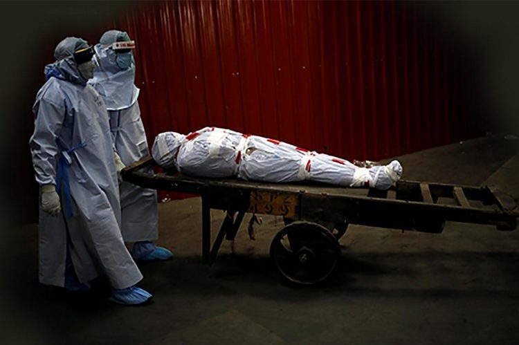 Health workers carry the body of a man who died due to the coronavirus disease (COVID-19) for his cremation at a crematorium in New Delhi, India, June 4, 2020. REUTERS/Adnan Abidi