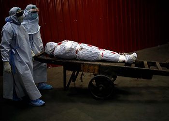 Health workers carry the body of a man who died due to the coronavirus disease (COVID-19) for his cremation at a crematorium in New Delhi, India, June 4, 2020. REUTERS/Adnan Abidi