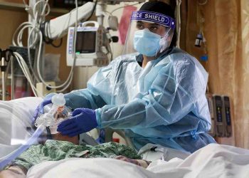 APPLE VALLEY, CALIFORNIA - DECEMBER 23:  (EDITORIAL USE ONLY) A clinician cares for a COVID-19 patient in the Intensive Care Unit (ICU) at Providence St. Mary Medical Center amid a surge in COVID-19 patients in Southern California on December 23, 2020 in Apple Valley, California. The 213 bed capacity hospital in San Bernardino County is currently treating at least 140 COVID 19-positive inpatients while operating at approximately 250 percent of ICU capacity. Southern California remains at zero percent of its ICU (Intensive Care Unit) bed capacity amid the spike in coronavirus cases and hospitalizations. (Photo by Mario Tama/Getty Images)
