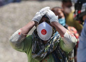 FILE- In this April 25, 2021, file photo, a relative of a person who died of COVID-19 reacts at a crematorium in Jammu, India. India’s death toll from COVID-19 has surpassed 200,000 as a virus surge sweeps the country, rooted in so-called super-spreader events that were allowed to happen in the months following the autumn when  the country had seemingly brought the pandemic under control. (AP Photo/Channi Anand, File)