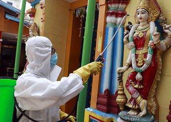 A member of the military wearing full protective gear sprays disinfectant at a Hindu temple to help curb the spread of the new coronavirus in Naypyitaw, Myanmar, Wednesday, April 1, 2020. The new coronavirus causes mild or moderate symptoms for most people, but for some, especially older adults and people with existing health problems, it can cause more severe illness or death. (AP Photo/Aung Shine Oo)
