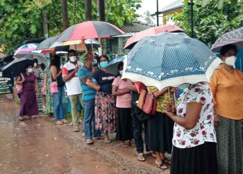 එන්නත් ලැබී නැත. එහෙත් එන්නතක් බලාපොරොත්තුවෙන් මහ වැස්සේ පෝලිම් ගැස සිටින මිනිස්සු...