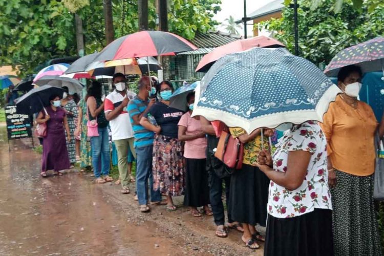 එන්නත් ලැබී නැත. එහෙත් එන්නතක් බලාපොරොත්තුවෙන් මහ වැස්සේ පෝලිම් ගැස සිටින මිනිස්සු...