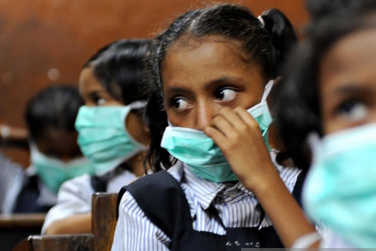 Indian school children, wearing protective masks distributed by the local right wing Shiv Sena party for an awareness campaign, are seen in a classroom in Mumbai on August 10, 2009. The number of people to die from swine flu in India rose to six, health officials said, as the government called for calm and people flocked to public hospitals for tests. The latest to die of the (A)H1N1 virus were an ayurvedic or traditional medicine practitioner in Pune, 120 kilometres (75 miles) from India's financial hub Mumbai, and a four-year-old boy in the southern city of Chennai.  AFP PHOTO/ Pal PILLAI (Photo credit should read PAL PILLAI/AFP via Getty Images)