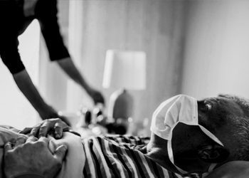 man has symptoms of the virus, lies in bed