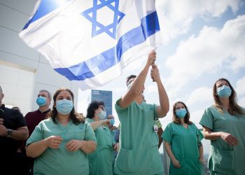 Israeli medical staff cheer an Israeli airforce acrobatic team flying over Ichilov hospital in Tel Aviv on Israel's 72nd Inependence Day. This year, the airforce will fly over all the hospitals in Israel as a way of honouring the medical staff during the Coronavirus outbreak. April 29, 2020.  Photo by Miriam Alster/Flash90 *** Local Caption *** יום העצמאות
מטס
תל אביב
איכילוב
קורונה
מטוסים
תל אביב
דגלים
דגל ישראל