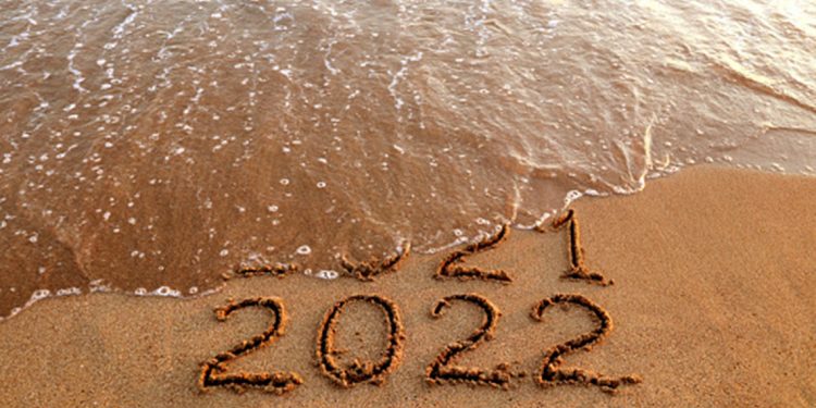 New year 2022 and old year 2021 on sandy beach with waves