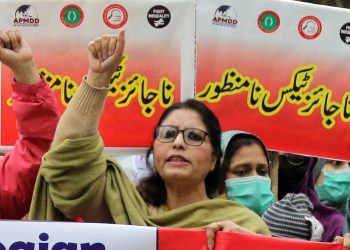 epa09700068 Supporter of Pakistan kissan rabita committee and fight inequality alliance holds a placard during a protest against inflation in Lahore, Pakistan, 21 January 2022. Protesters demanded an end to rising inflation and the failure of the government to control the prices of basic commodities.  EPA/RAHAT DAR