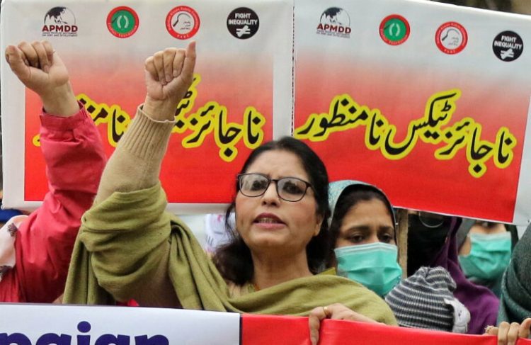 epa09700068 Supporter of Pakistan kissan rabita committee and fight inequality alliance holds a placard during a protest against inflation in Lahore, Pakistan, 21 January 2022. Protesters demanded an end to rising inflation and the failure of the government to control the prices of basic commodities.  EPA/RAHAT DAR