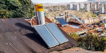 Solar panels and satellite dishes are installed on ancient tiled roofs in the slums of Ankara, Turkey. Garbage and old roofs of huts against the background of a panorama of a modern Turkish city