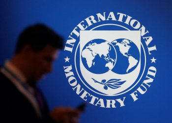 FILE PHOTO: A participant stands near a logo of IMF at the International Monetary Fund - World Bank Annual Meeting 2018 in Nusa Dua, Bali, Indonesia, October 12, 2018. REUTERS/Johannes P. Christo