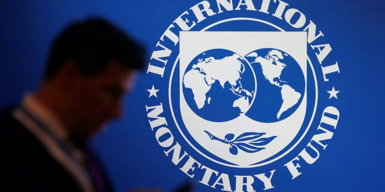 FILE PHOTO: A participant stands near a logo of IMF at the International Monetary Fund - World Bank Annual Meeting 2018 in Nusa Dua, Bali, Indonesia, October 12, 2018. REUTERS/Johannes P. Christo