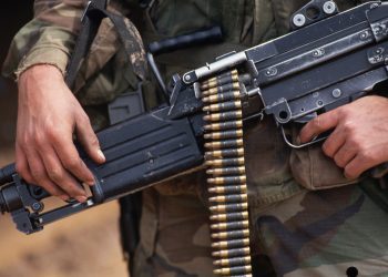 1993, Hohenfels, Germany --- A soldier holds a machine gun loaded with 5.56 caliber ammunition which it fires in short bursts. Hohenfels, Germany. --- Image by © Leif Skoogfors/CORBIS