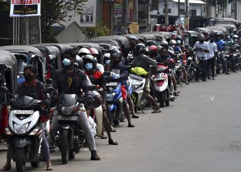 Motorbikes and three-wheeler vehicles queue to fill their tanks up at a Ceylon Petroleum Corporation fuel station in Colombo on April 12, 2022. - Crisis-stricken Sri Lanka defaulted on its $51 billion external debt on April 12 after running out of dollars to import desperately needed goods and sparking widespread protests demanding the president's resignation. (Photo by Ishara S. KODIKARA / AFP)