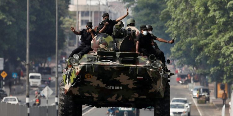Army members travel on an armoured car on the main road after the curfew was extended for another extra day following a clash between Anti-government demonstrators and Sri Lanka's ruling party supporters, amid the country's economic crisis, in Colombo, Sri Lanka, May 11, 2022. REUTERS/Dinuka Liyanawatte