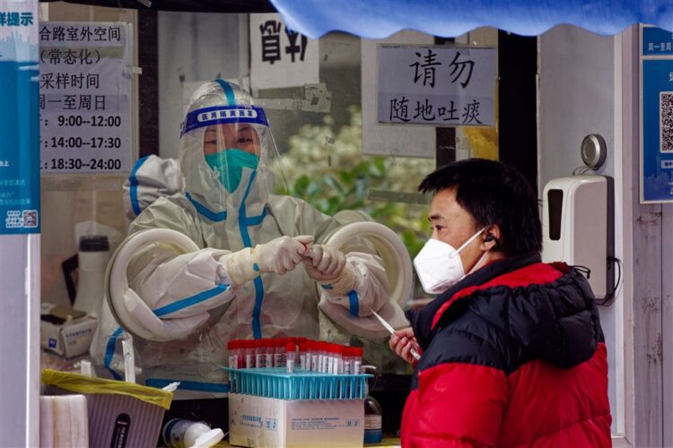epa10365069 A man takes Coronavirus PCR test in the street testing booth, in Shanghai, China, 14 December 2022. China will no longer report asymptomatic cases of Covid-19 in its daily report, according to the National Health Commission announcement on 14 December. With easing Covid-19 restrictions, a rising number of infections is circulating in Shanghai. This year the holiday season is decorated with people staying at home recovering from the virus. Shopping malls and restaurants are mostly empty, while people can be seen on the streets in the morning before and in the evening after work.  EPA-EFE/ALEX PLAVEVSKI