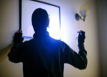 Unrecognizable male burglar stealing an artwork.