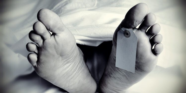 closeup of the feet of a dead body covered with a sheet, with a blank tag tied on the big toe of his left foot, in monochrome, with a vignette added