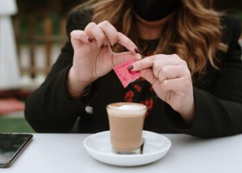 A young woman having a coffee wearing a protective face mask