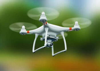 Creative abstract 3D render illustration of professional remote controlled wireless RC quadcopter drone with 4K video and photo camera for aerial photography flying in the air outdoors with selective focus effect