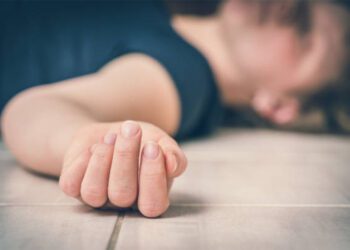 Dead woman lying on the white floor - suicide concept
