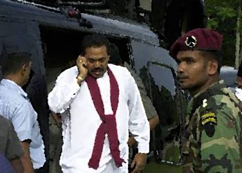 MATARA, SRI LANKA:  Sri Lanka's Prime Minister Mahinda Rajapakse talks on the phone as he exits a helicopter to address a meeting in the southern town of Matara, 14 November 2005, on the final leg of his campaigning for the presidential elections on 17 November 2005.  Sri Lanka deployed troops amid fears of suicide bomb attacks against presidential candidates staging their final campaign rallies ahead of the elections.   AFP PHOTO/Lakruwan Wanniarachchi  (Photo credit should read LAKRUWAN WANNIARACHCHI/AFP via Getty Images)