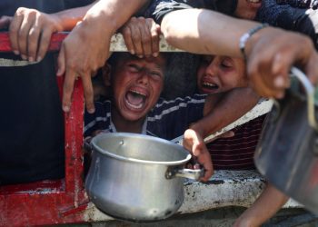 Palestinians wait to receive food from a charity kitchen, amid a hunger crisis, in Gaza City, July 23, 2025. REUTERS/Mahmoud Issa     TPX IMAGES OF THE DAY