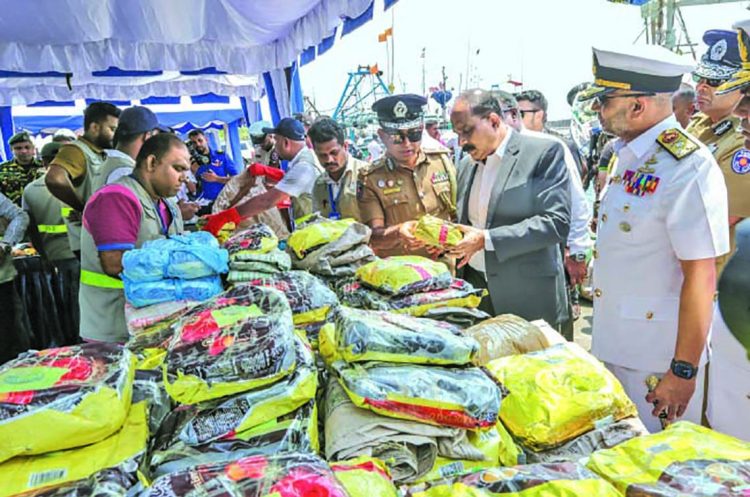 "ශ්‍රී ලංකා නාවික හමුදාව විසින් දික්ඕවිට වරායට රැගෙන ආ මත්ද්‍රව්‍ය සහ ගිනිඅවි අසුරා ඇති අයුරු සහ එම ස්ථානය පරීක්ෂා කරන නිලධාරීන් නිරූපණය වන ඡායාරූපයකි."